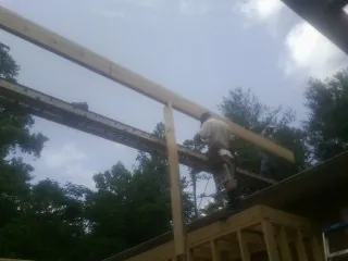 Carpenter setting a ridge beam over a new addition frame — Ice Dam Removal by Roofing Brothers in Brothers