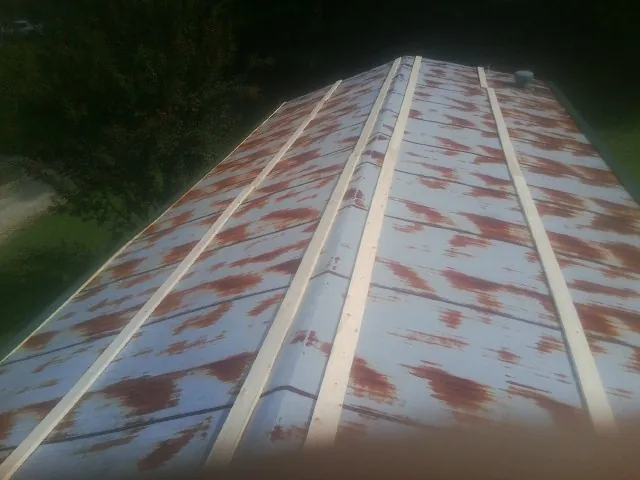 Rusted metal roof panels with new wood purlins before replacement — Storm Damage Roof Repair in Brothers by Roofing Brothers