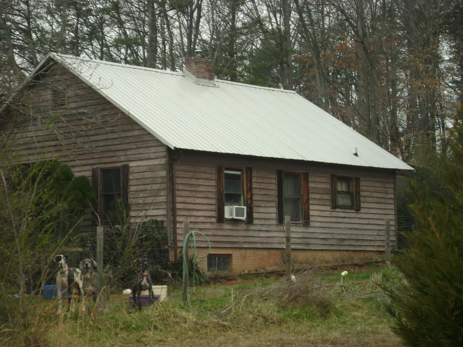White metal roof on an old wood sided farmhouse, from a Metal Roof Installation job in Brothers